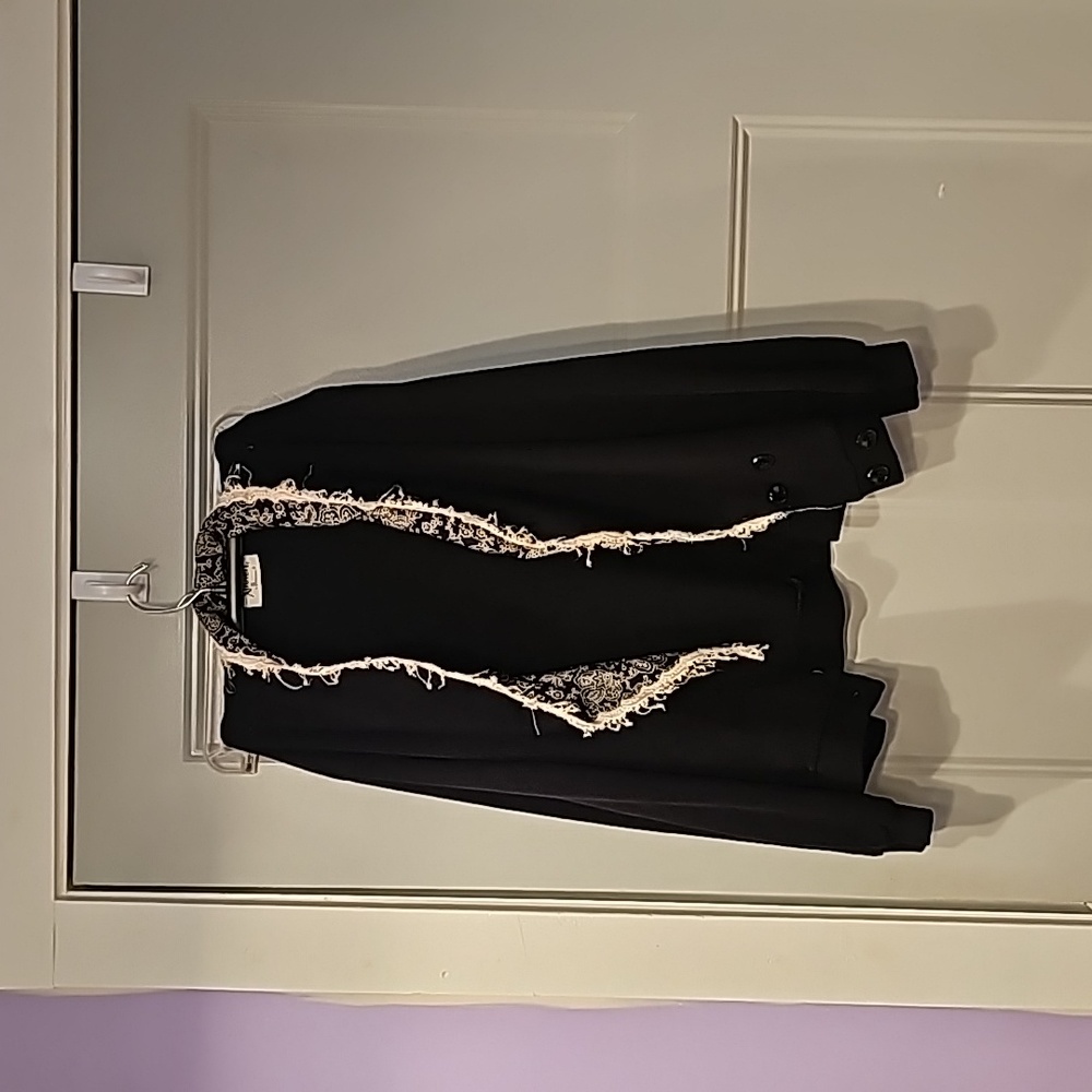 Black jacket with collard white print and ruffles. Sized large.